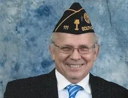 A man in a suit and tie wearing an american legion hat.